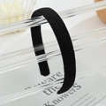Close-up of a soft black velvet headband displayed on a modern acrylic stand - Black