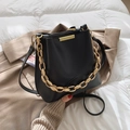 Chic black matte bucket bag with bold gold chain handle and slim shoulder strap - Black