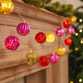 Faceted Christmas globe string lights in red, pink, and gold on a warm fireplace - 1.5m 10-LED Battery Powered / Red Yellow Rose Ball