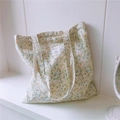 Dettaglio della borsa tote in cotone a fiori con etichetta tessuta e doppi spallacci - Giallo Oca Floreale