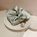 Dettaglio scrunchie in raso di seta verde salvia con cuore dorato e ciondolo perla - Verde