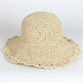Detailed close-up of woven paper straw texture on a wide-brimmed beach hat in beige - Beige