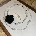 Detalle de collar de perlas de doble capa con un colgante de flor de camelia negra - Collar-Blanco-Negro