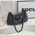 Detail of dark grey quilted shoulder bag featuring a purple and mint green knotted charm - Dark Gray