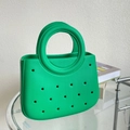 Détail d'un sac de plage EVA vert citron montrant les trous et la poignée circulaire - Vert