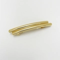 Close-up of golden double-bar metallic hair clip with a polished punk style finish - Cylindrical Gold