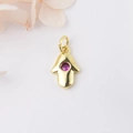 Gold Hamsa Hand pendant with a vibrant pink gemstone set on a clean white background - Rose Red Zirconia