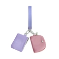 Dettaglio di una pochette viola con zip e mini portafoglio rosa con cinturino da polso - Viola