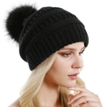Detailopname van zwarte gebreide muts met grote pompon van imitatiebont op model - Eén maat / Zwart