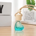 Hartvormig 6ml glazen parfumflesje met blauwgroene vloeistof en houten dop op hout - Gouden draad vijf-lijns dop / Hemelsblauw