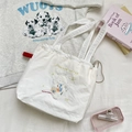 Detail der weißen Canvas-Tasche mit Hunde-Stickerei und Kordelzug-Verschluss - Weiß