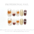 Detail of luxury press-on nails featuring amber marble, gold 3D relief, and red cat eye effect - Latte Amber (182)