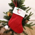 Red and white knitted Christmas stocking with embroidered letter C on a tree - Letter C