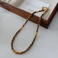 Tiger eye beaded necklace with golden metal spacers in a classic jewelry display tray - Tiger Eye Necklace XL0286
