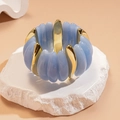 Macro view of blue acrylic and gold metal segments on an elastic bracelet against stone - Sky Blue Metal Patchwork / Blue