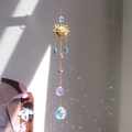 Garden suncatcher with gold sun face, blue crystals, and rainbow light reflection - A19
