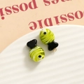 Detail showing handcrafted green and black glass fish charms on a textured white tray - 3D Color Matching Fish / Yellow Green and Black