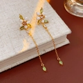 Dettaglio orecchini a fiore smaltati in oro con petali bianchi e foglie verdi su libro - Orecchini(Perno in Argento)-Oro-Bianco