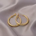 Elegant gold hoop earrings with high-polish finish on soft purple silk background - E-023---Gold 50mm