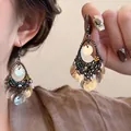 Detailaufnahme von Boho-Perlenohrringen mit Muschel-Anhängern und bronzener Webung - Stil 2 Haken Weiße Blume
