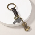 Macro detail of vintage bronze keychain with violin charm and engraved leather strap - Violin
