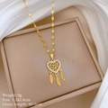 Vue détaillée du collier attrape-rêves coeur doré avec plumes sur une boîte à bijoux - Pendentif En Cuivre Chaîne En Acier Titane Or
