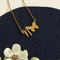 Golden butterfly and letter M charm necklace on blue velvet stand - Gold N