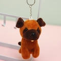 Detail of a brown plush puppy keychain with a small bell and metallic keyring - 10cm / Dark Brown