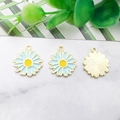 Flat lay of enamel daisy flower charms with blue petals and golden metal details - 16x18mm / Light Blue