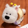 White curly puppy plush toy wearing a yellow bee costume on a wooden surface - Bee Dog