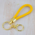 Yellow braided leather rainbow keychain with gold metal clasp on light wood background - Generation 1 Round Dragon Woven Buckle (Light Gold) / Yellow