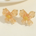Detailed close-up of golden floral earrings with orange resin petals and crystal centers - Light Orange Crushed Stone Flower Stud Earrings