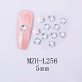 Close-up of 5mm aurora star nail art charms with iridescent effect on a pink glitter nail - 5-Point Star - White Mocha (L256)