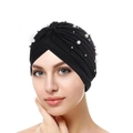 Detail of black pleated turban hat with assorted white pearls on a model portrait - Black