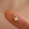 Französischer Mini-Gold-Vorhängeschloss-Anhänger mit Diamant auf einer Fingerspitze - Gold