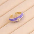 Dettaglio anello dorato smalto viola con zircone su vassoio portagioie in beige - Taglia Unica(Regolabile) / Viola