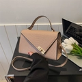 Détail de la texture croco rose et du fermoir doré sur un sac à main élégant - Kaki
