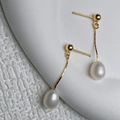 Macro view of teardrop freshwater pearl earrings with gold 925 silver fringe tassels - Gold