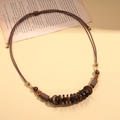 Détail du collier bohème avec perles en bois et fleur en noix de coco sur fond vintage - Marron