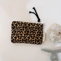Close-up of leopard print cotton makeup bag with white zipper and woven brand label - Brown and Yellow Leopard Print