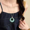 Detailed macro view of a blue marbled circular pendant necklace on a denim outfit - Round / Blue