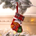 Christmas stocking with brown bear and tree on snowy pine branch near fireplace - E-W04 Small Plaid Bear Stocking