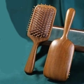 Natural sandalwood air cushion hair brushes for scalp massage on green fabric - Sandalwood Square Air Cushion Comb
