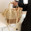 Details der zweifarbigen Strohtasche mit Champagner-Seidenschleife und gewebtem Gurt - Beige