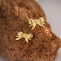 Elegant gold butterfly stud earrings made of stainless steel on natural rock background - Gold Bowknot (EH125)