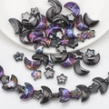 Macro shot of iridescent purple and black moon and star charms for DIY jewelry making - Half Gun Black Purple