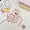 Flat lay of pink floral drawstring storage bag with rabbit ear design for cosmetics - Light Pink