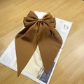 Brown satin oversized bow hair clip with long ribbons on a fashion magazine - Dark Coffee