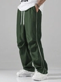 Detail view of dark green cargo pants with side white stripes and adjustable drawstring - Dark Green
