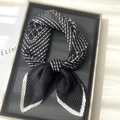 Vista dettagliata di un foulard in seta a pieghe a righe bianche e nere con trama fine - Nero